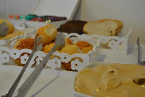 a bunch of different types of pastries on a table at Premium Vila Velha Ponta Grossa in Ponta Grossa