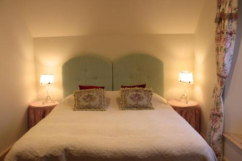 a bedroom with a large bed with two lamps at The School House in Lochgilphead