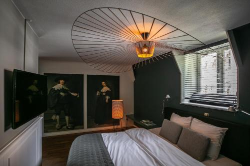 a bedroom with a bed and a chandelier at Kasteeltje Hattem in Roermond