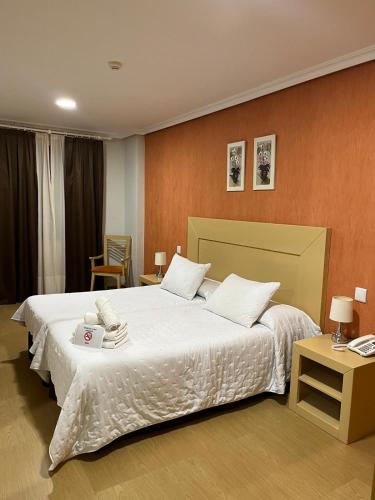 a bedroom with a large bed with white sheets at Hostal Jijones in Villarrubia de los Ojos