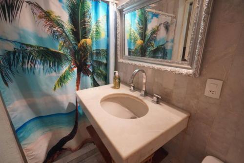 a bathroom with a sink and a palm tree mural at Habitacion Machado in Mazatlán