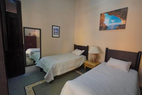 a bedroom with two beds and a mirror at Casa Feliz Playa Norte in Mazatlán