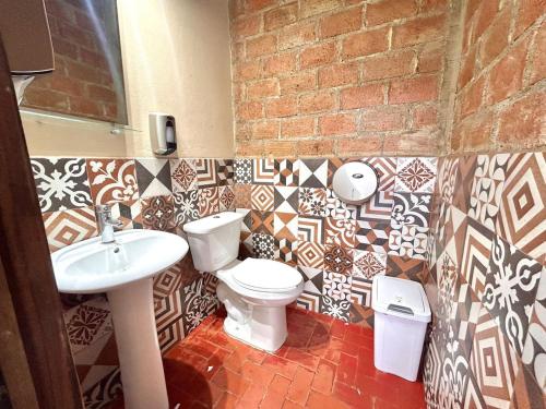 a bathroom with a toilet and a sink at Casa Feliz Playa Norte in Mazatlán