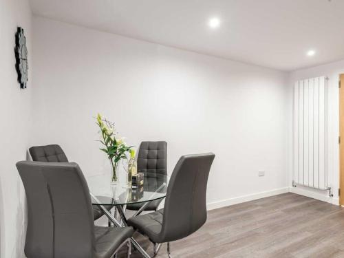 a dining room with a glass table and chairs at Casa Fresa - Castlehill Apartment in Dundee