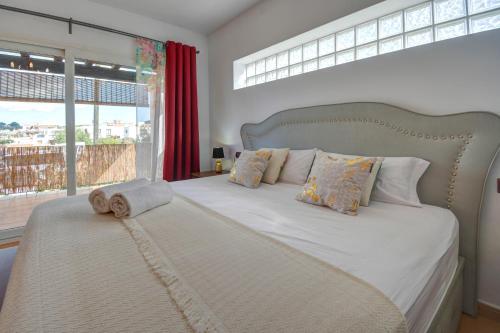 a bedroom with a large bed with a large window at Villa Ca Paulina in San Antonio