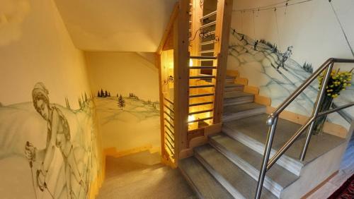 a staircase in a room with a mural on the wall at Hotel Boton D'Or & Wellness a La Thuile in La Thuile