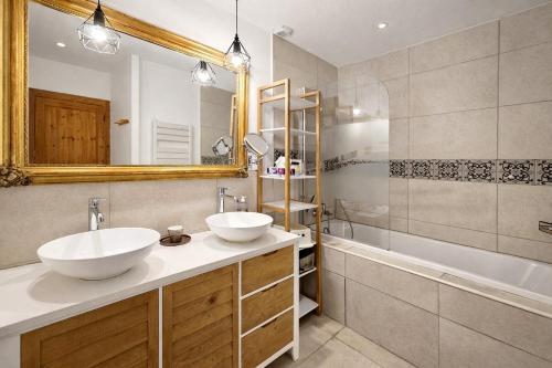 a bathroom with two sinks and a tub and a mirror at Ferme du Grand Breton - Chambres et Table d'hôtes in Beaumont-de-Lomagne