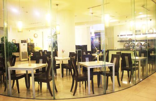 jadalnia ze stołami i krzesłami w restauracji w obiekcie River Hotel w mieście Jiayi