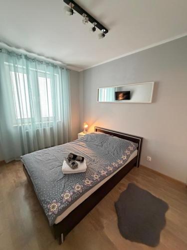 a bedroom with a bed with a pair of shoes on it at Modern in Suwałki