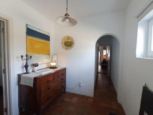 a room with a wooden dresser and a hallway at Monte das Andorinhas Alentejo in Montemor-o-Novo