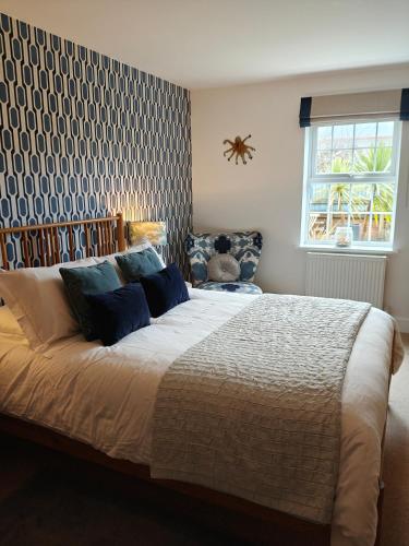 a bedroom with a large bed with blue pillows at No 12 in Lyme Regis