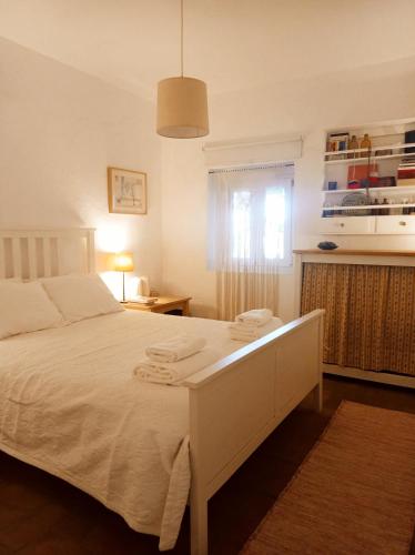 a bedroom with a white bed and a window at Monte das Andorinhas Alentejo in Montemor-o-Novo