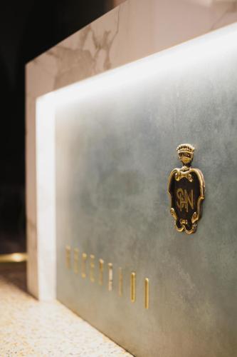 a gold sign on the side of a shelf at Hotel San Nicola in Altamura