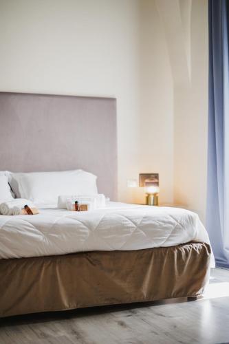 a bedroom with a large bed with white sheets at Hotel San Nicola in Altamura