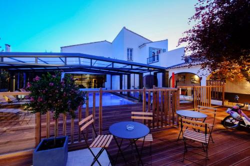 a deck with tables and chairs and a swimming pool at Hôtel de La Marée - Face à l'océan - Ile de Ré in Rivedoux-Plage