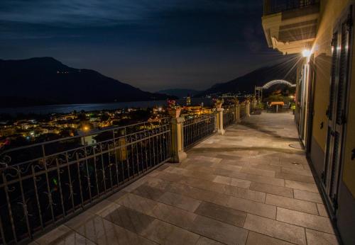 a balcony with a view of the ocean at night at Villa Perla del Lago in Vercana