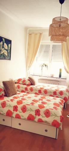 a bedroom with a bed with red flowers on it at Chez Ninon in Freyming