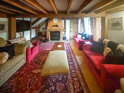 a living room with red couches and a fireplace at Rumbolds Retreat in Plaistow