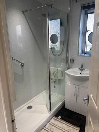 a bathroom with a shower and a sink at Grayrigge Croft Cottage in Grange Over Sands