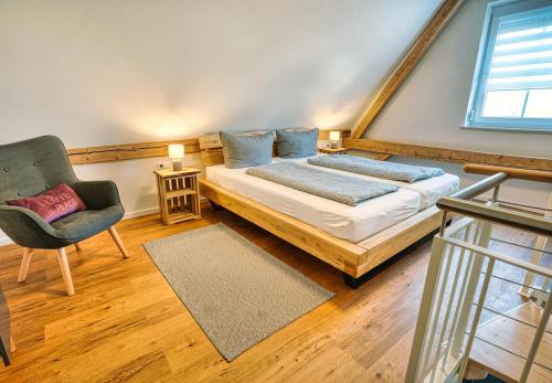 a bedroom with a bed and a chair at Ferienwohnungen Etzl in Bad Mergentheim