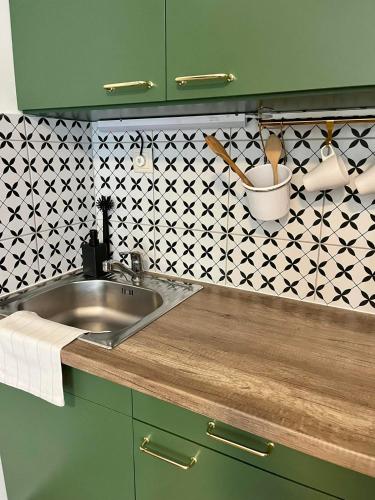 a kitchen with a sink and a black and white tiles at Harmónia Panzió in Bogács