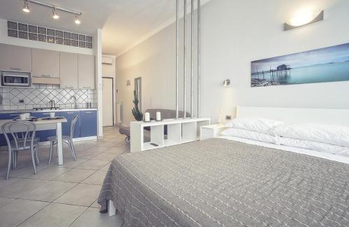 a bedroom with a large bed and a kitchen at Excelsior in Piombino