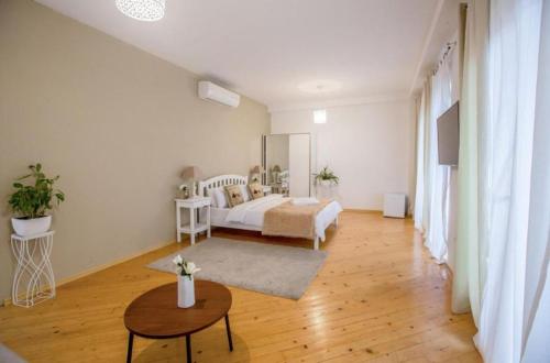 a white bedroom with a bed and a table at Boutique Hotel Meidan View in Tbilisi City
