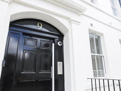 a black door on a white building with a window at Casa Fresa - King Street Apartments in Dundee