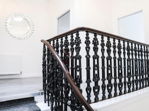a staircase with a black railing in a house at Casa Fresa - King Street Apartments in Dundee