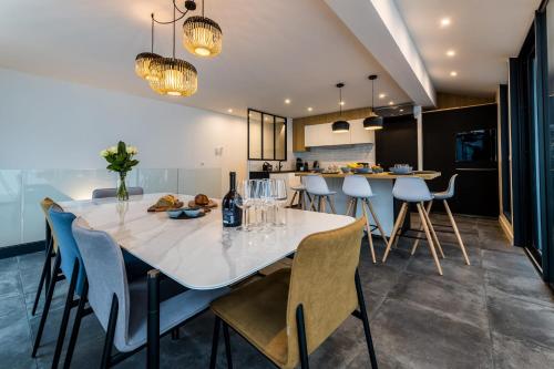 a kitchen and dining room with a white table and chairs at BLOOMY - Villa Biarritz in Biarritz