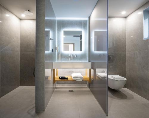 a bathroom with a sink and a toilet at Oscar Suites & Village in Agia Marina Nea Kydonias
