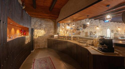a kitchen with stone walls and a counter with a sink at Golden Heights Resort in Al Ḩanī