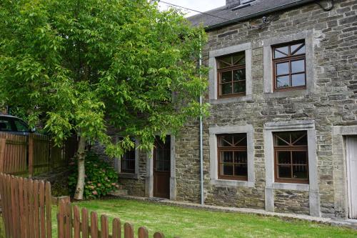 Maison Matan في Houdremont: منزل حجري قديم أمامه شجرة