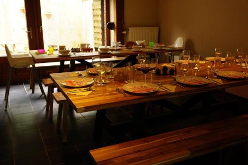 een lange houten tafel met borden en glazen erop bij Maison Matan in Houdremont