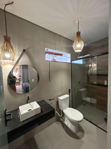a bathroom with a toilet and a sink and a mirror at Casa Green Ville in Prado
