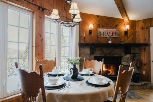 a dining room with a table and a fireplace at Charme-Nord in Sainte-Agathe-des-Monts