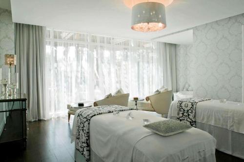 a hotel room with two beds and a large window at Eau Resort & Spa in South Palm Beach