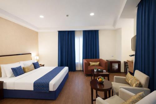 a hotel room with a bed and a couch at Hotel Amber Palace in Gurgaon