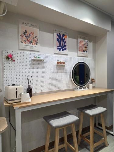 a counter with two bar stools and a mirror at Bom Stay in Seoul