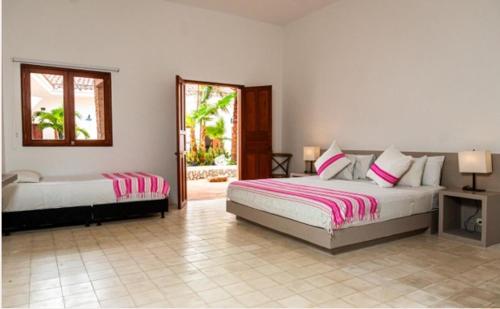 a bedroom with two beds and a mirror at Hotel San German in Girardot