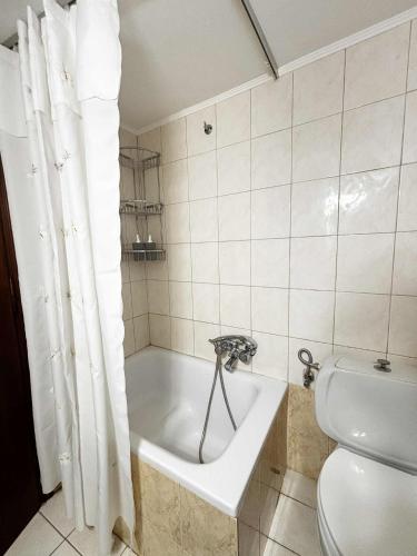 a bathroom with a bath tub and a toilet at Blue View in Livadia