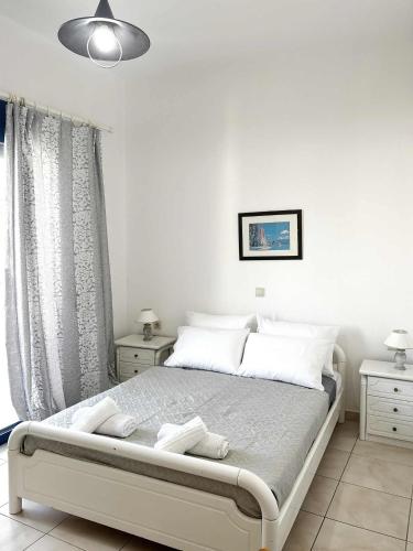 a white bedroom with a bed with white pillows at Blue View in Livadia