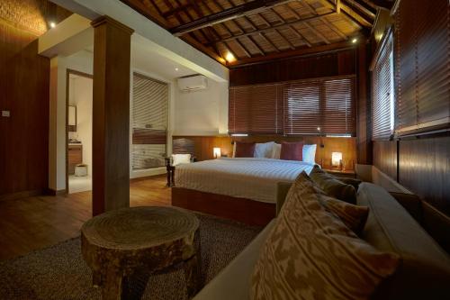 a large bedroom with a bed and a couch at Juan Villa Legian in Seminyak