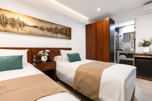 a hotel room with two beds and a bathroom at Achilleos City Hotel in Larnaca