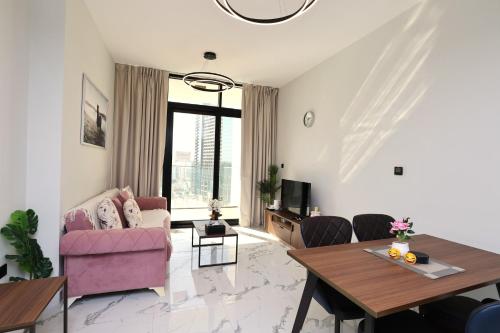 a living room with a pink couch and a table at 1 Bedroom 1 Min walking to Cleveland and Galleria Mall by Central Stay in Abu Dhabi