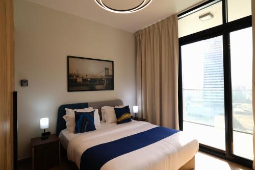 a bedroom with a bed and a large window at 1 Bedroom 1 Min walking to Cleveland and Galleria Mall by Central Stay in Abu Dhabi