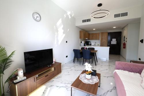 a living room with a couch and a tv and a table at 1 Bedroom 1 Min walking to Cleveland and Galleria Mall by Central Stay in Abu Dhabi