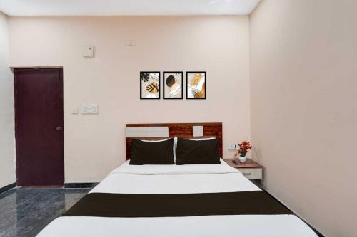 a bedroom with a large white bed and two pictures on the wall at Collection O Delta Electronics Metro Station Bangalore Formerly New Kick in Kammasandra