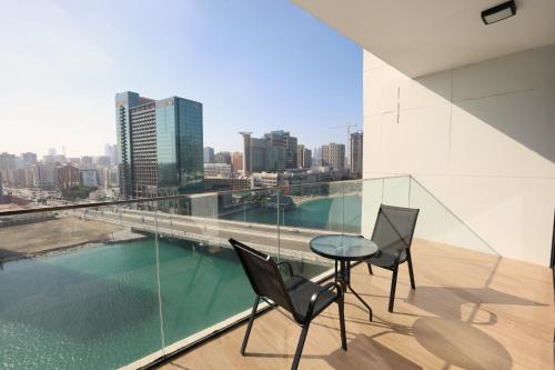 a balcony with a table and chairs and a view of the city at 1 Bedroom 1 Min walking to Cleveland and Galleria Mall by Central Stay in Abu Dhabi