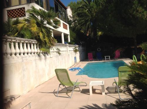 - une piscine avec 2 chaises longues à côté d'une maison dans l'établissement La Nectarine, à Nice
